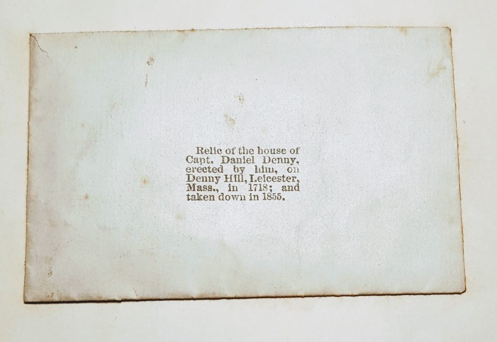 A small envelope with typed text "Relic of the house of Capt. Daniel Denny, erected by him, on Denny Hill, Leicester, Mass. in 1718, and taken down in 1855"