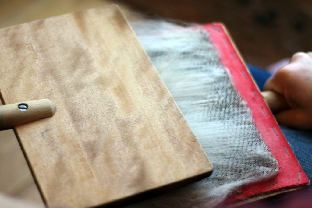 hand carders being used to card fleece