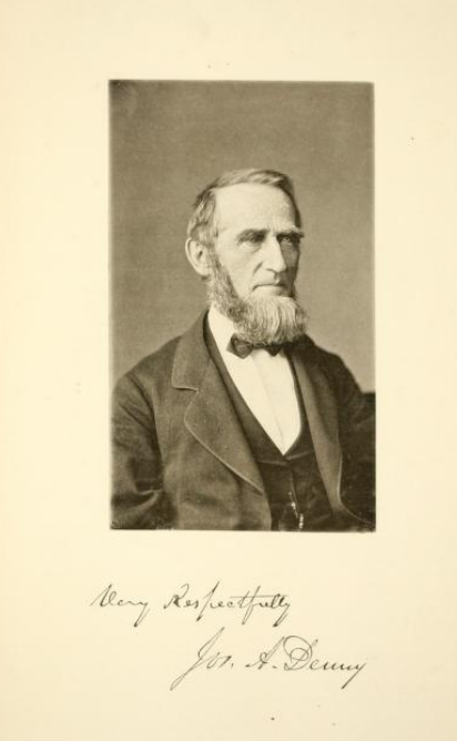 Photograph of Jos. A. Denny, seated, wearing a suit.